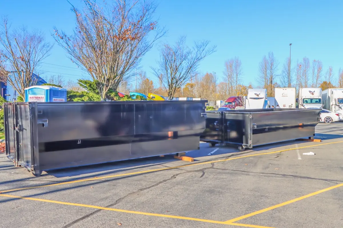 Professional dumpster rental service with roll-off container on residential driveway in West Pennsboro